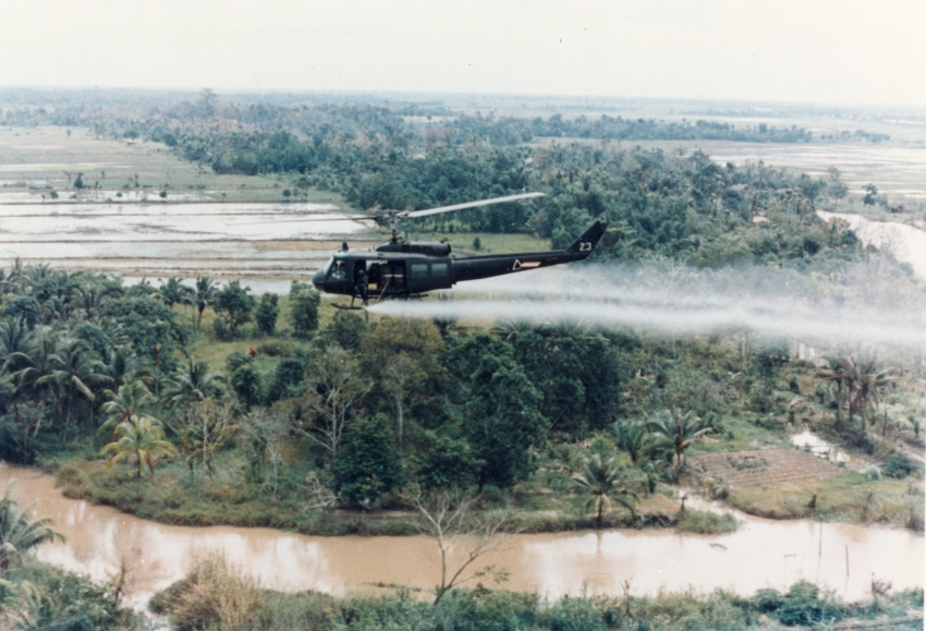US Army helicopter spraying Agent Orange over Vietnam. Public Domain